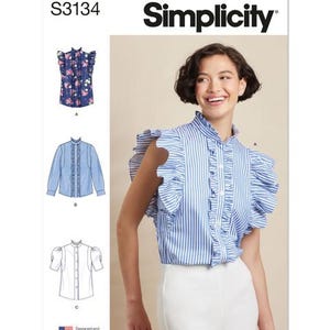 May include: Simplicity pattern S3134 features a woman wearing a blue and white striped blouse with ruffled sleeves. The pattern includes illustrations of different blouse styles, including a floral print and a solid blue option. The text "Simplicity" is displayed at the top.