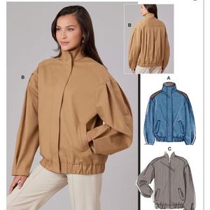 May include: McCall's sewing pattern M8629 features a tan jacket with a stand-up collar, pockets, and a gathered waist. The pattern also includes designs for a denim jacket and a striped jacket. The American flag is visible.