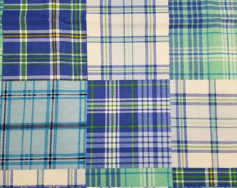 May include: A patchwork textile featuring a variety of plaid patterns in shades of blue, green, and white. The design is composed of rectangular blocks, each showcasing a different variation of the plaid, creating a visually interesting and textured surface.