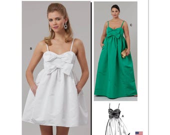 Könnte beinhalten: McCall's Schnittmuster M8581 mit drei Kleiderdesigns. Die Kleider umfassen ein weißes Minikleid mit Schleife, ein grünes bodenlanges Kleid mit Schleife und eine schwarz-weiße Kleidskizze. Das Muster ist in den USA entworfen und gedruckt.