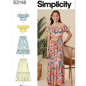 May include: Simplicity sewing pattern S3148. The image shows a young person wearing a floral two-piece outfit. The outfit includes a crop top and a long skirt. The pattern also shows illustrations of the outfit in different colors and styles.