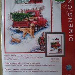 May include: Winter Ride counted cross stitch kit featuring a red pickup truck with a Christmas tree in the back, a golden retriever, and a snowy winter scene. The kit includes 14 count white Aida fabric, presorted thread, a needle, and instructions. Design by Greg Giordano.