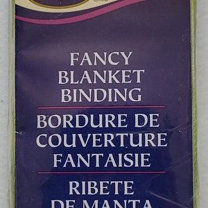 May include: A package of green fabric trim labeled "Fancy Blanket Binding" in English and French. The package includes 4.75 yards or 4.34 meters of trim. The product number is PC798.