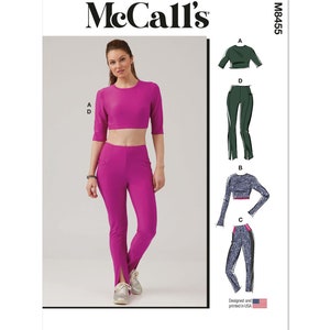 May include: McCall's sewing pattern M8455 for a crop top and pants. The pattern shows a woman wearing a pink crop top and matching pink pants with a slit at the bottom of each leg. The pattern also shows a green crop top and pants and a blue and gray crop top and pants.