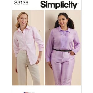 May include: Simplicity pattern S3136 features two women modeling button-down shirts and pants. One woman wears a light pink shirt and beige pants. The other wears a lavender shirt and matching pants. The pattern is designed and printed in the USA.