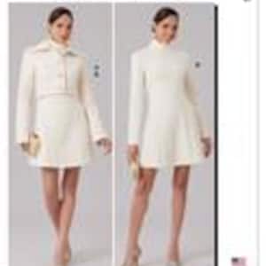 May include: McCall's sewing pattern featuring two women's outfits. One outfit is a cream-colored, collared jacket and matching skirt. The other is a cream-colored, long-sleeved dress with a high neckline. The pattern includes the American flag.