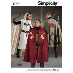 May include: Simplicity sewing pattern number 8771 for three hooded cloaks with different embroidered designs. The cloaks are in white, red, and green with black trim. The designs include a dragon, a stag, and a wolf.