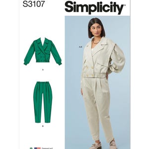 May include: Simplicity sewing pattern S3107 for a cropped jacket and pants. The jacket has a double breasted closure and a collar. The pants have a high waist and are pleated. The model is wearing a light beige version of the jacket and pants. The pattern is designed and printed in the USA.