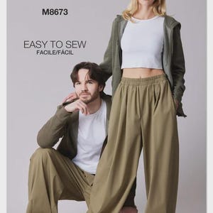 May include: McCall's M8673 sewing pattern envelope featuring a white crew neck t-shirt, olive green zip-up hoodie, and matching olive green wide-leg trousers with an elastic waistband. The text reads McCall's, M8673, and EASY TO SEW FACILE/FÁCIL.