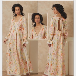 May include: Vogue Patterns V2189 sewing pattern envelope featuring a floor-length dress with a light pink base and a multi-colored floral print. The dress has long sleeves with ruffled cuffs, a deep V-neckline, a back cutout with a tie, and lace trim.