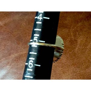 May include: A gold ring with a blue stone set in a silver bezel. The ring is sized on a ring sizer that shows a size 6.