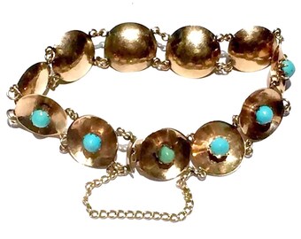 Puede incluir: Un brazalete de oro con una cadena y eslabones redondos. Cada eslabón tiene una piedra turquesa engastada en el centro.