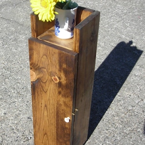 Toilet paper holder for storage of toilet paper or cleaning supplies.