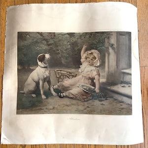 May include: A vintage print titled Attention featuring a young child in a bonnet and light-colored dress sitting on the ground with a white and brown dog. The child holds a plate of dark fruit near a small wooden cart in a wooded outdoor setting.