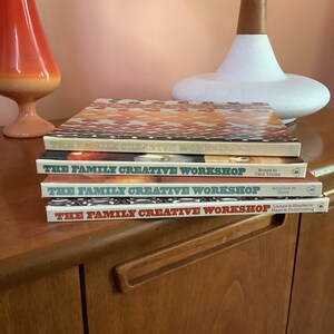 May include: A stack of four vintage books titled "The Family Creative Workshop" with various craft topics. The top book has a patterned cover in shades of orange and brown. The other books have white spines with red and green text.