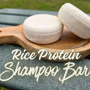 以下が含まれることがあります： 黒いハンドルが付いた白いセラミックマグカップ。太字の黒いフォントで「But First, Coffee」と書かれています。マグカップはぼやけた背景に配置され、そのクリーンなデザインを強調しています。