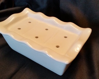 May include: White ceramic soap dish with a wavy edge and six drainage holes.