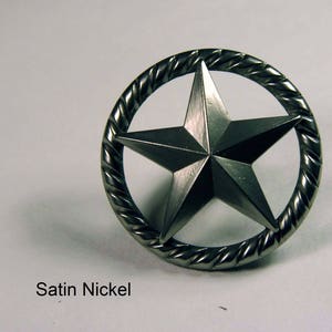 May include: A satin nickel star-shaped decorative element. The star is centered within a circular frame with a twisted rope design. The text "Satin Nickel" is printed below the star.
