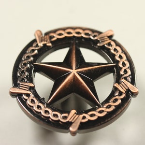 May include: A copper-colored five-pointed star surrounded by a black ring with a copper-colored barbed wire design.