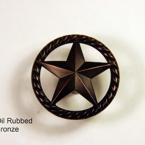 May include: Oil rubbed bronze cabinet knob with a five-pointed star design surrounded by a rope-like border.