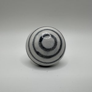 May include: White ceramic knob with black concentric circles.