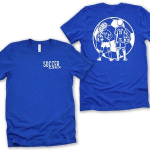 May include: Blue t-shirt with the text "SOCCER mom" on the front. The back of the shirt features a white silhouette of two children playing soccer with the names "KYLIE" and "CALEB" on their jerseys.
