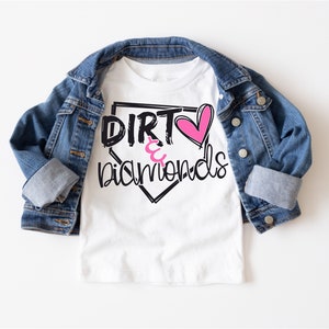 May include: White t-shirt with a black and white baseball diamond graphic. The graphic says "Dirt & Diamonds" with a pink heart in the middle.