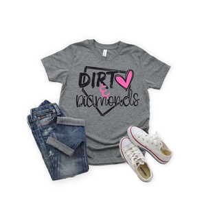 May include: A gray t-shirt with a baseball diamond graphic and the text "Dirt & Diamonds" in black with a pink heart.