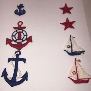 May include: Set of six embroidered iron-on patches featuring nautical and patriotic themes. The set includes three blue anchors, two red stars, and a white sailboat with red and blue accents.