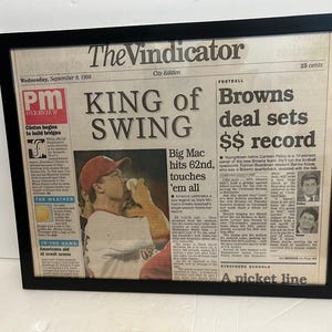May include: A black and white newspaper clipping from The Vindicator, dated September 9, 1990, with the headline "KING of SWING Browns deal sets $$ record". The article features a photo of a baseball player in a red and white uniform, with the caption "Big Mac hits 62nd, touches 'em all".