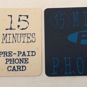 May include: Two Pepsi phone cards. The card on the left is white with a blue and red Pepsi logo and the text "15 minutes pre-paid phone card". The card on the right is blue with the text "15 minutes Pepsi pre-paid phone card" in white.