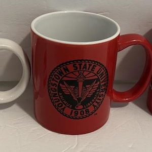 May include: Three ceramic mugs. One white mug with red text that reads "YOUNGSTOWN STATE 1994 NATIONAL CHAMPIONS". The second mug is red with a black seal that reads "YOUNGSTOWN STATE UNIVERSITY 1908". The third mug is red with white text that reads "WN STATE MATICS".