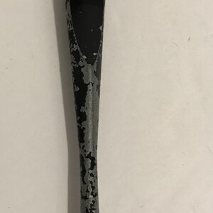 May include: A vintage glass cutter with a metal head and handle. The handle is black with silver paint chipping off, and the cutting head has multiple small wheels. The tool is designed for cutting glass.