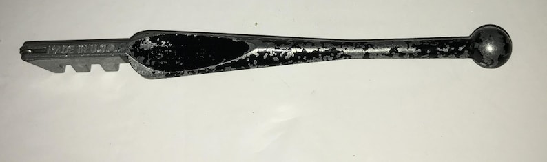 May include: A vintage glass cutter with a silver finish and a black handle. The tool has a cutting head with multiple teeth and the text "MADE IN U.S.A."