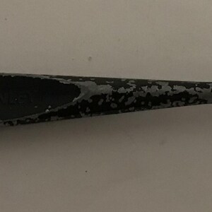 May include: A glass cutter with a gray and black handle and a cutting head. The text "MADE IN U.S.A." is visible on the cutting head. The tool is designed for cutting glass.