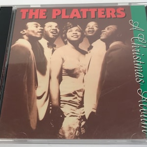 May include: A CD case featuring the album "A Christmas Album" by The Platters. The cover has a sepia-toned image of the group and the text "THE PLATTERS" in red. The album title is in green script.