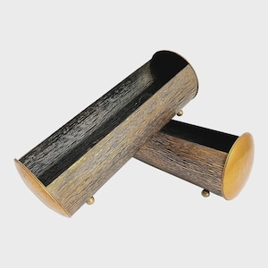 May include: Two gold and black metal cylindrical planters with a textured finish. The planters are stacked on top of each other.