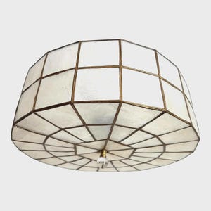 May include: A geometric ceiling light fixture with a white, segmented shade and bronze-colored metal framing. The light has a clear, teardrop-shaped glass finial and a brass-colored base. The shade is composed of numerous rectangular and trapezoidal panels.