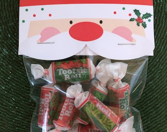 Könnte beinhalten: Eine durchsichtige Plastiktüte gefüllt mit Tootsie Roll Bonbons. Die Tüte ist mit einem roten und weißen Weihnachtsmann-Gesicht verziert.