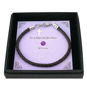 May include: A dark brown braided leather bracelet with a silver-toned metal cross charm and lobster clasp. The bracelet is displayed on a light purple card inside a black box, featuring the printed text "To a Special Brother" and "With Love".
