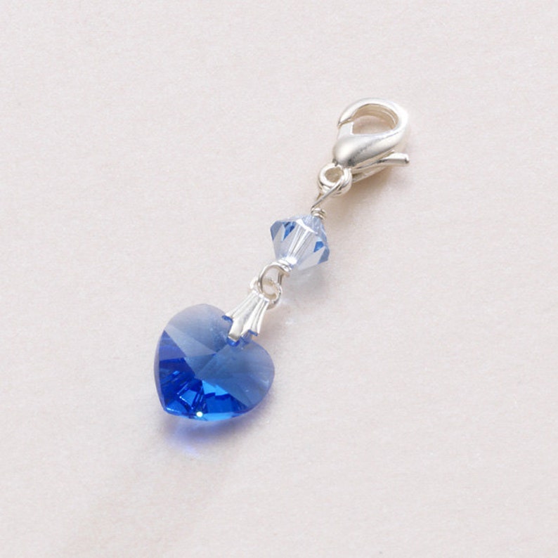 Pretty Something blue charm featuring a blue crystal heart at the bottom with a smaller bicone shaped crystal also