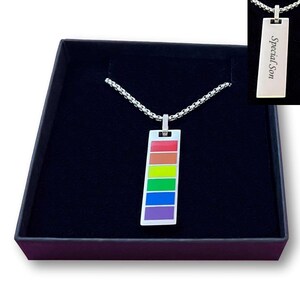 May include: A silver-toned rectangular pendant necklace featuring a vertical rainbow-coloured enamel stripe design. The reverse side of the pendant is engraved with the text Special Son. The necklace includes a silver-toned box chain.