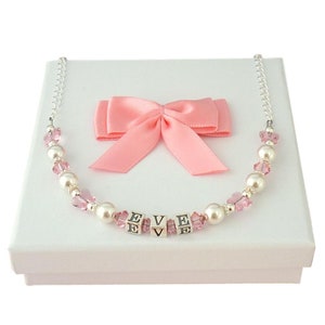 Collier prénom pour fille en argent sterling avec perles blanches et cristaux roses, dans une boîte cadeau avec carte-cadeau.