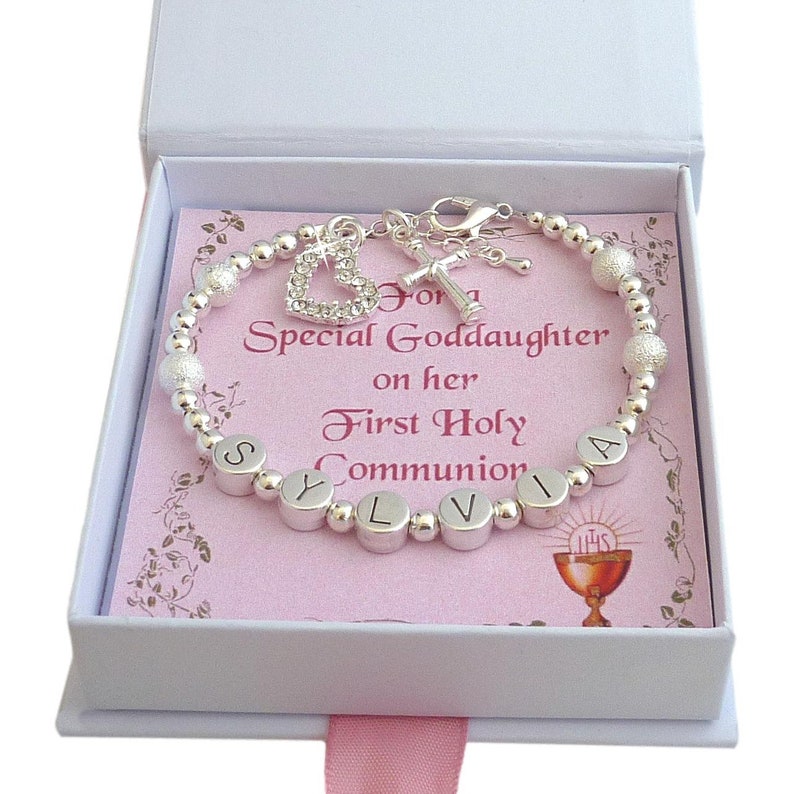 Stunning bracelet for a girls First Holy Communion, any name can be added in letters beads, Silver plated large sparkle beads and smaller round silver beads. Featuring a cross and sparkling open heart charms by the clasp