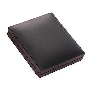 May include: A rectangular, closed storage box with a smooth, matte black finish. The box features a hinged lid design with clean, sharp edges and a solid, uniform dark surface, presenting a simple and functional container for small items.