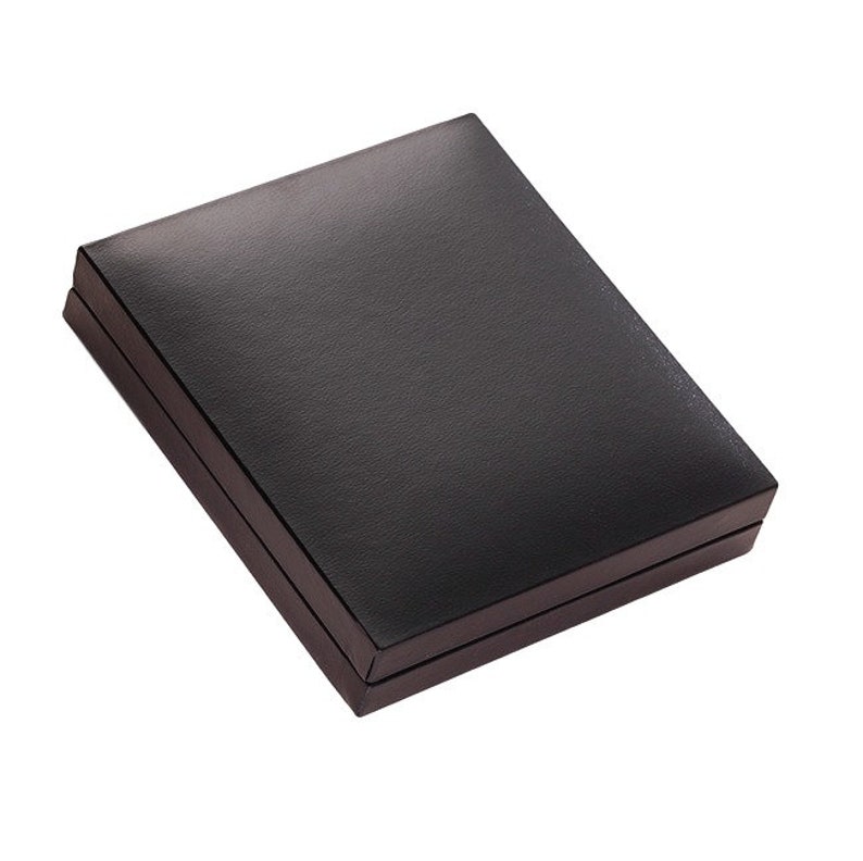 May include: A rectangular, closed storage box with a smooth, matte black finish. The box features a hinged lid design with clean, sharp edges and a solid, uniform dark surface, presenting a simple and functional container for small items.