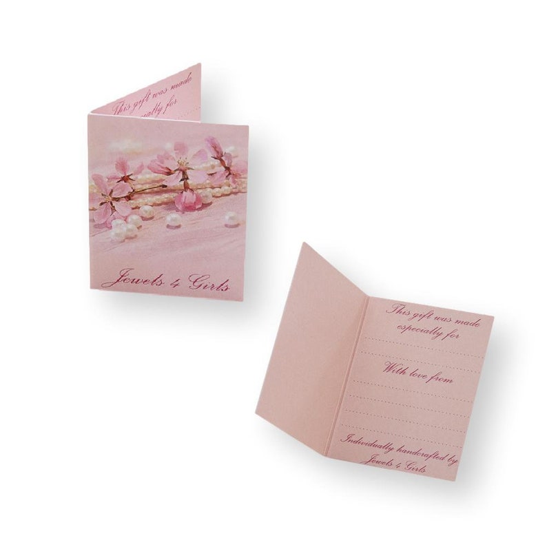 May include: Two light pink folded gift cards. The left card features a floral and pearl graphic with the text "Jewels 4 Girls". The right card is open, displaying the printed text "This gift was made especially for", "With love from", and "Individually handcrafted by Jewels 4 Girls" with blank lines for writing.