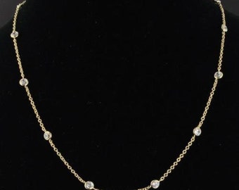 May include: A gold chain necklace with small clear stones evenly spaced along the chain.