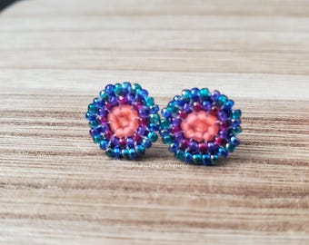 Pendientes de cuentas tejidas con forma de círculo degradado arcoíris y diseño caprichoso.