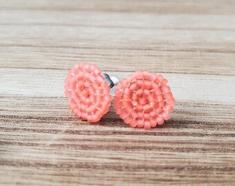 Pendientes tejidos con cuentas de semillas y círculos de color naranja neón.